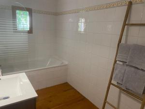 a white bathroom with a tub and a sink at Appartement en Provence in Châteaurenard