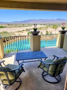 een patio met 2 stoelen en een tafel op een balkon bij Family-friendly Riverfront mansion pool and spa in a calm cove of the Colorado River in Bullhead City
