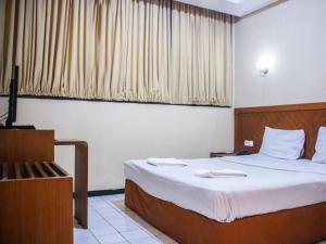 سرير أو أسرّة في غرفة في Hotel Sukamulya Pasteur