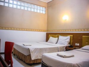 سرير أو أسرّة في غرفة في Hotel Sukamulya Pasteur