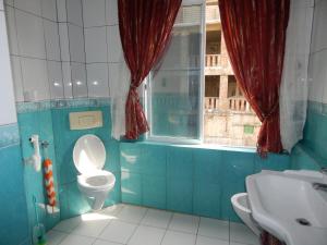 a bathroom with a toilet and a sink and a window at Blue pearl in Beruwala