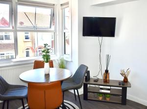 a living room with a table and chairs and a tv at Seaside Flat, Contractors, Family, Business, Parking in Portslade