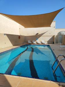 a large swimming pool with chairs in a building at Al Raya Hotel Apartments in Dubai