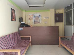 una sala d'attesa con due panche e un bancone di Hotel Tayatha a Tawang