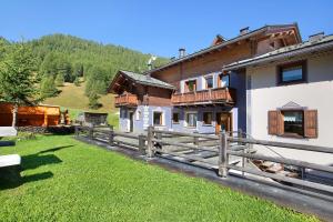dom z drewnianym płotem przed nim w obiekcie Appartamento 3 w Livigno