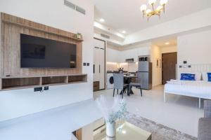 a living room with a flat screen tv on a wall at Elegant Studio with Pool View and Great Facilities in Dubai