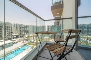 a chair on a balcony with a view of a pool at Elegant Studio with Pool View and Great Facilities in Dubai