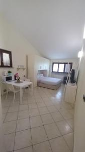 a large white room with a bed and a table at Monolocale Azzurra in Magione