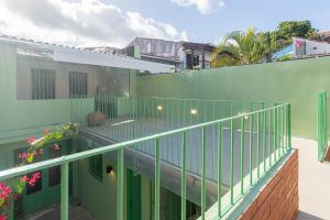 Casas Amparo Manupiá في أوليندا: شرفة مع سور أخضر بجوار مبنى