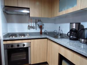 a kitchen with a stove and a sink at Departamento Aquamar in Viña del Mar