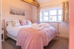 a bedroom with a bed with towels on it at Cariad - Spacious 3 bed, group getaway Luxury Cottage with Private Hot Tub in Denbigh