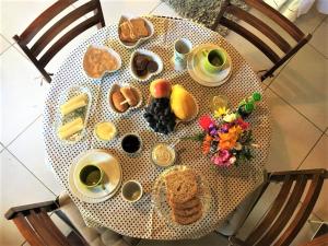 a table with plates of food and cups of coffee at Pousada Boutique Rancho Campanário in Rancho Queimado
