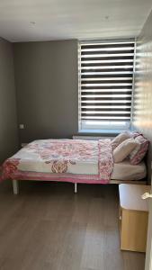 a bed in a room with a window and a bedspread at Casa Polizzi - Maison entière in Fontaine-lʼÉvêque