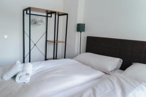 a white bed with two pillows on top of it at Stadtapartment KUS in Klagenfurt