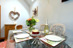a dining room table with plates and a cake on it at Woodshed Cottage in Ashbourne +3 photos