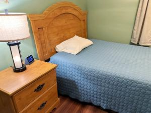 Normans CovePort suite @ The Homestead Oceanfront的一间卧室配有一张床,梳妆台上配有一盏灯