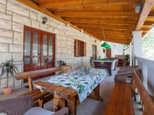 uma sala de jantar com uma mesa e uma mesa de bilhar em Charming holiday home with private pool and covered terrace em Škrip
