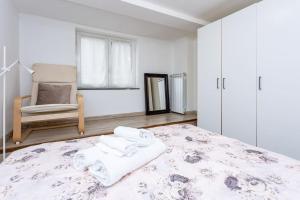 um quarto com uma cama com uma cadeira e toalhas em Apartment Adorno 2 - Affitti Brevi Italia em Gênova