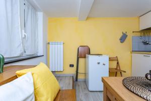 uma cozinha com um frigorífico branco e uma mesa em Apartment Adorno 2 - Affitti Brevi Italia em Gênova