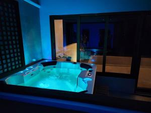 a jacuzzi tub in a room with blue lighting at Royal Seascape in San Juan