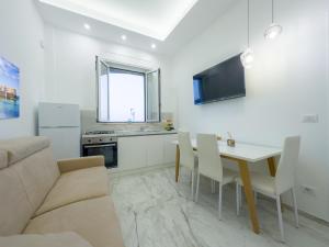 Una cocina y una sala de estar con una mesa y un sofá. en Fronte Mare Relais Stapane, en Gallipoli