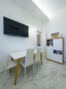 Un comedor blanco con una mesa y sillas blancas. en Fronte Mare Relais Stapane, en Gallipoli 14 fotos más