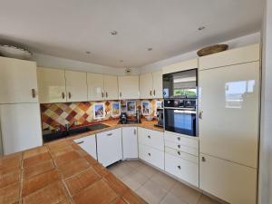 a kitchen with white cabinets and a tile floor at Villa Les Voiles in Cannes