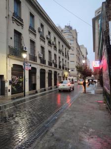un coche está conduciendo por una calle de la ciudad por la noche en Un lugar perfecto en CABA, en Buenos Aires