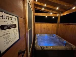 a hot tub in a wooden room with a sign at Fully Loaded Cabin In Heart Of Pigeon Forge in Pigeon Forge