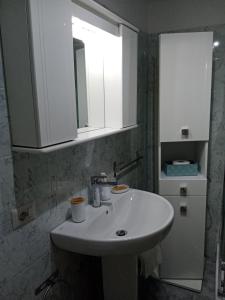 un bagno con un lavandino bianco e uno specchio di La Dimora di Pietra a Gubbio