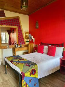 Parklands Shade Hotel في نيروبي: غرفة نوم بسرير وجدار احمر