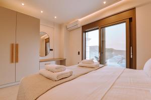 a bedroom with a large bed with towels on it at Milion Living Residences in Parga