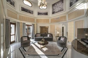 Royal Suite at The San Roque Club في سان روكي: غرفة معيشة مع أريكة وكراسي وطاولة