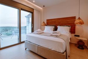sypialnia z dużym łóżkiem i dużym oknem w obiekcie MiLiON RESIDENCES w mieście Parga