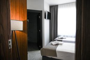 a hotel room with two beds and a television at Hotel LIBERO Delchevo in Delčevo