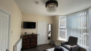 a living room with a chair and a television at ANFIELD PLACE TO STAY in Liverpool