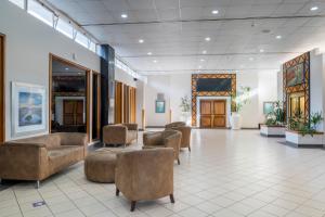 a lobby with couches and chairs in a building at Holiday Inn - Mutare by IHG in Umtali