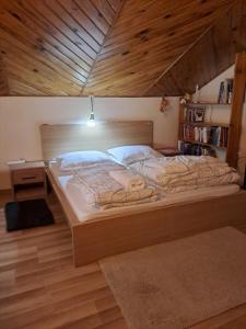 een groot bed in een kamer met een houten plafond bij Villa Kasztanowa in Skierniewice