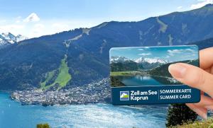 a person holding up a sign with a picture of a mountain at Apartment Annemarie in Zell am See
