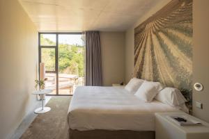 a hotel room with a bed and a window at Hotel Viura in Villabuena de Álava