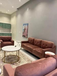 un soggiorno con divano e tavolo di شاليهات الاطلالة a Al Khobar