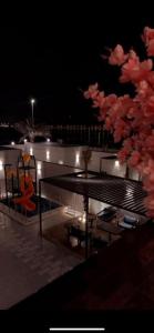 eine Terrasse eines Bootes in der Nacht mit einem Tisch und Stühlen in der Unterkunft شاليهات الاطلالة in Khobar