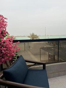 une chaise bleue assise au-dessus d'un balcon dans l'établissement شاليهات الاطلالة, à Khobar