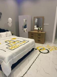 1 dormitorio con cama, tocador y espejo en شاليهات الاطلالة en Al Khobar