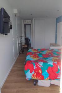 een slaapkamer met een bed met een bloemendeken bij Ile du Ponant in Ploemeur
