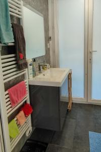 La salle de bains est pourvue d'un lavabo et d'un sèche-serviettes. dans l'établissement Ile du Ponant, à Ploemeur