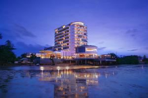 a building is lit up at night next to a body of water at BW Suite Belitung in Tanjungpandan