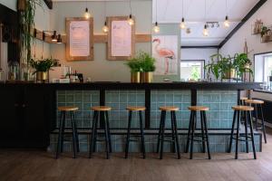 eine Bar in einem Restaurant mit Barhockern an der Theke in der Unterkunft Luxe Vakantiehuis Huismus Veluwe in Nunspeet