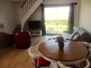 a living room with a table and chairs and a couch at Cottage Lillstugan proche de la Baie de Somme in Quesnoy-le-Montant