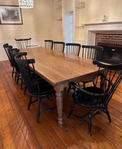 einem Holztisch mit schwarzen Stühlen und einem Kamin in der Unterkunft Pinetown Bridge Bnb LLC 